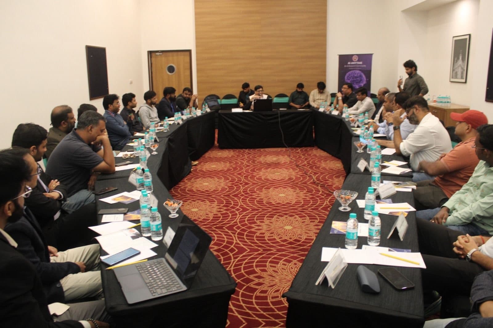 Leadership AI roundtable in a hotel conference room with an AI Anytime banner